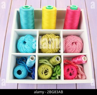 Multicolored skeins of thread in wooden box closeup Stock Photo