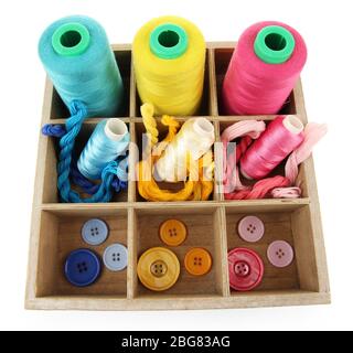 Multicolored skeins of thread and buttons in box isolated on white Stock Photo
