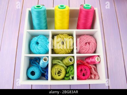 Multicolored skeins of thread in wooden box closeup Stock Photo
