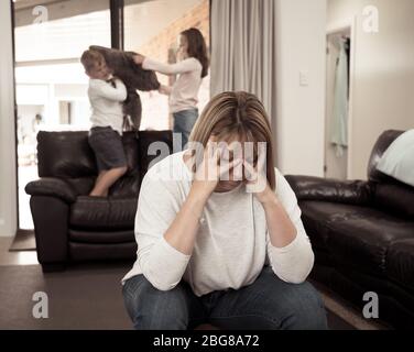 COVID-19 Isolation and mental health. Stressed out parents struggling with having the children at home during Coronavirus lockdown. Overwhelmed mother Stock Photo