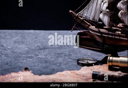 Columbus Day. Pirates and treasure with vintage worldmap and discovery of old equipment. Copy space on dark background. Stock Photo