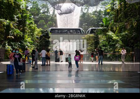 31.01.2020, Singapore, Republic of Singapore, Asia - People are seen in front of the vortex indoor waterfall at Changi Airport's new Jewel Terminal. Stock Photo