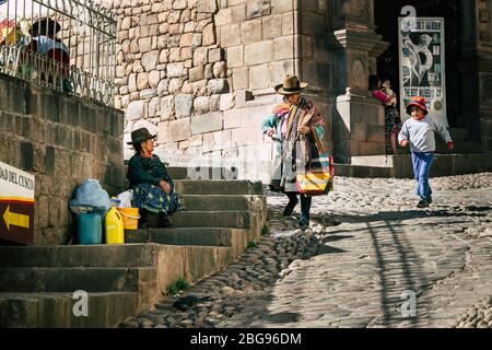 local women and child in Cusco's cobblestone street - Latin American street life (Peru) Stock Photo