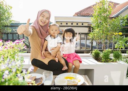 muslim woman and kids breakfast at home on the rooftop garden Stock Photo