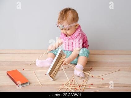 Girl playing with matches. Dangerous situation at home. A small
