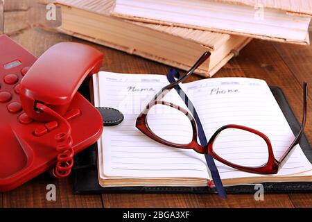 Telephone and notepad and other items, on wooden background Stock Photo