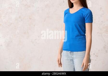 Young woman in stylish t-shirt on light background Stock Photo