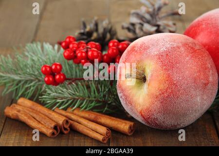 Red apples with fir branch on wooden background Stock Photo
