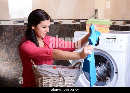 Beautiful young woman erases in house Stock Photo