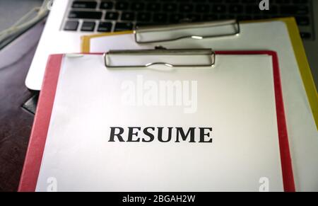 Closeup of resume on top of computer laptop on table with pen Stock Photo