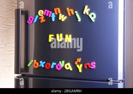 Word Fun spelled out using colorful magnetic letters on refrigerator Stock Photo