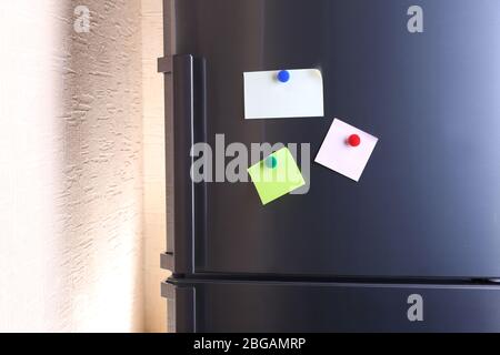 Empty paper sheets on fridge door Stock Photo