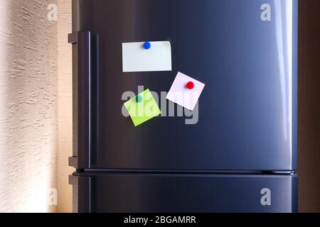 Empty paper sheets on fridge door Stock Photo