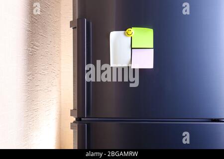 Empty paper sheets on fridge door Stock Photo