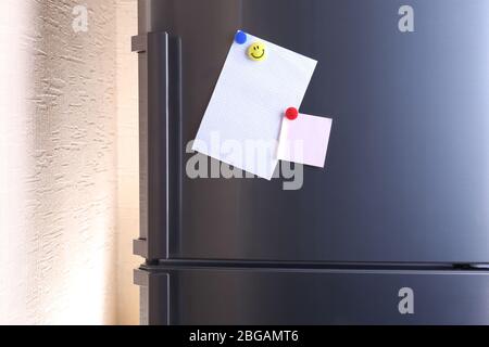 Empty paper sheets on fridge door Stock Photo