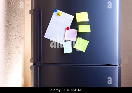 Empty paper sheets on fridge door Stock Photo