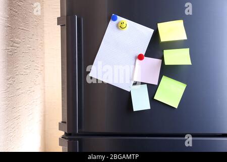 Empty paper sheets on fridge door Stock Photo