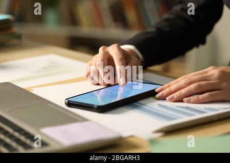 Close up of entrepreneur woman hands signing contract on smart phone with finger at night Stock Photo