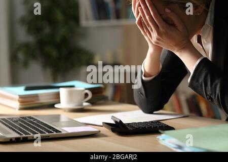 Close up of entrepreneur woman complaining over bad results at night sitting on a desk at home office Stock Photo