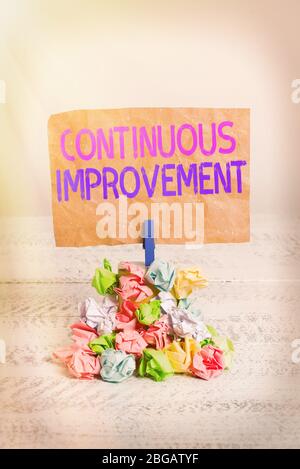 Text sign showing Continuous Improvement. Business photo text Ongoing Effort to Advance Never ending changes Reminder pile colored crumpled paper clot Stock Photo