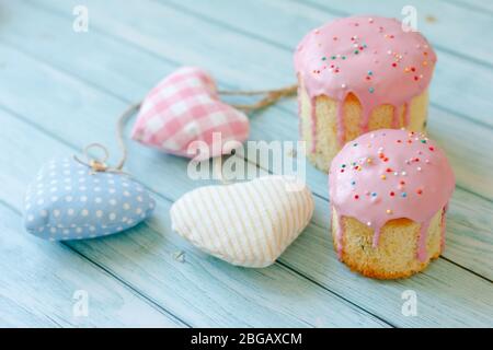 Decoration of easter cake. Pastry chef hands decorate fudge with flowers, green leaves and sweet colored confetti. Festive baked bread. Easter Stock Photo