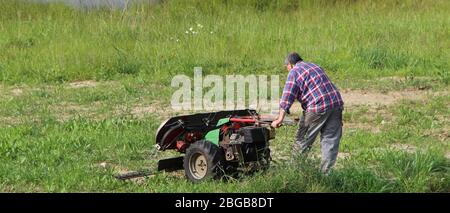 Industrial size petrol driven walk behind mower to harvest grass lone