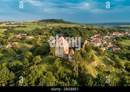 Aerial drone view of Slimnic Fortress (Stolzenburg), located on a Burgbasch hill on a Sibiu-Mediaș road in Transilvania, Romania. Travel spots in Roma Stock Photo