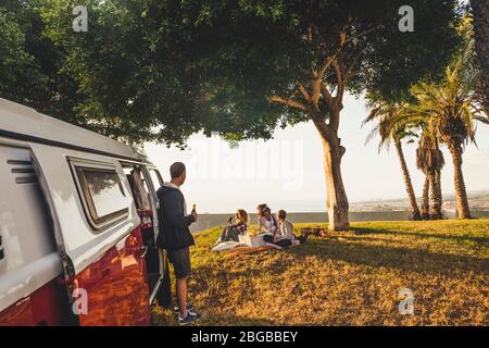Group of friends  enjoy together outdoor leisure activity picnic in summer sprig beautiful weather day - red vintage vehicle and friendship concept ea Stock Photo