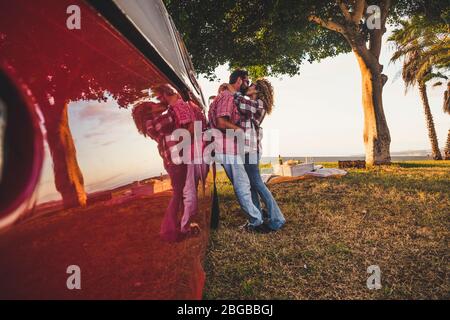 Romantic adult of caucasian couple kiss and hug together in outdoor leisure activity picnic in summer and spring funny day - people without social dis Stock Photo