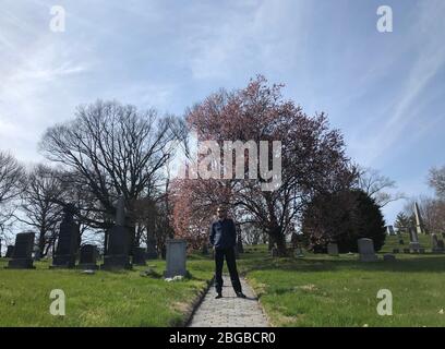 New York, USA. 20th Apr, 2020. Nicholas Weigand-Suminski, assistant director, is standing at Greenwood Cemetery, where he often takes walks during the Corona Crisis. New York is the epicenter of the Corona pandemic in the USA. Nevertheless, everyday life continues during the pandemic, even for five Germans. (To dpa: 'Between worry and hope: New York's Germans in the Corona Crisis') Credit: Benno Schwinghammer/dpa/Alamy Live News Stock Photo