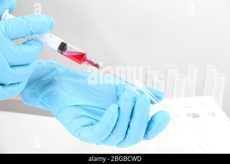 Technician injecting blood sample in test tube analysis, isolated on white Stock Photo