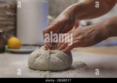 Woman's hands kneading home made bread dough on a flour covered table surface Stock Photo