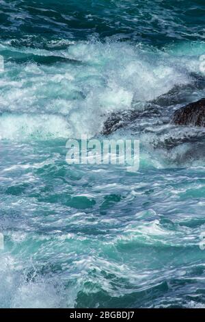 Aquatic background of sea surf waves splashing close up with clear blue green water and white foam Stock Photo