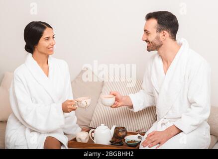 Man and a woman drinking wellness tea in a spa slon. Couple enjoys relaxation at resort and spa Stock Photo
