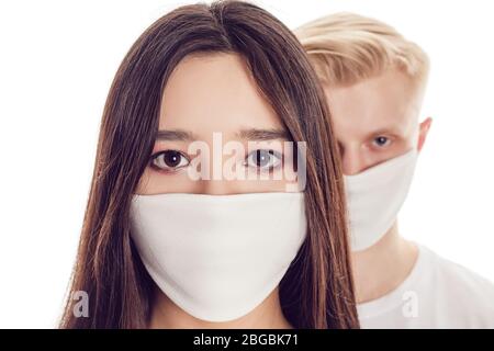 Couple of young people in protective face masks isolated on white. Stock Photo