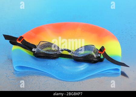 Swim cap and goggles on silver background Stock Photo