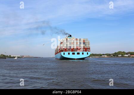 blue containership on river elbe Stock Photo