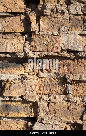 Texture of an old brick wall close up. Red collapsed brick. Background of red brick wall. Stock photo vertical. Stock Photo