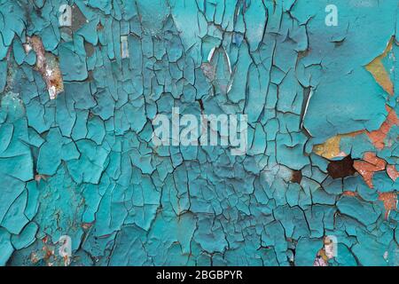 The texture of the old painted wall is covered with cracks and roughness close-up. Stock photo of old paint with cracks. Turquoise paint. Stock Photo