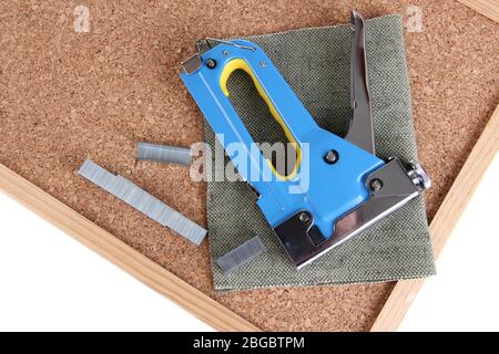 Construction stapler and staples on cork board close up Stock Photo