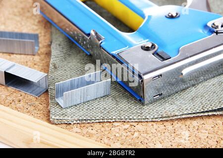 Construction stapler and staples on cork board close up Stock Photo