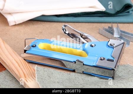 Construction stapler with fabric and staples on cork board close up Stock Photo