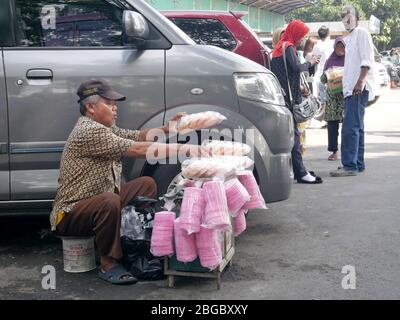 https://l450v.alamy.com/450v/2bgbxxy/a-crackers-seller-tidy-up-his-merchandise-beside-a-car-in-a-parking-lot-2bgbxxy.jpg