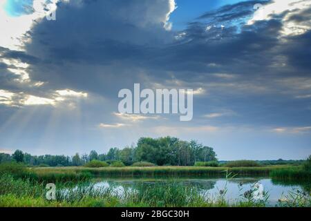 Storm dramatic clouds over a quiet forest lake. Gloomy clouds. Soft focus Stock Photo