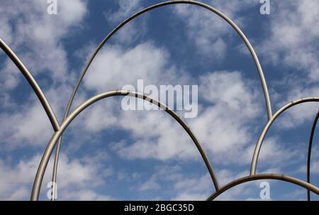 View of gigantic, modern sculpture with cloudy blue sky background in Barcelona port. It is named Waves (Onades) by Andreu Alfaro. It is a sunny summe Stock Photo