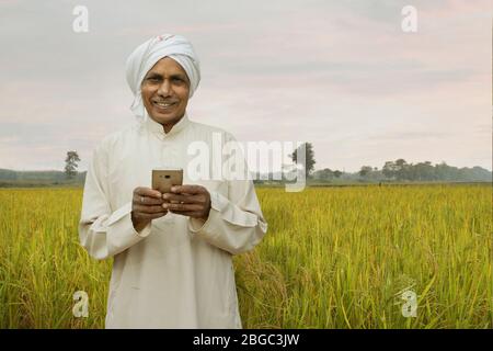 farmer with cellphone smiling Stock Photo