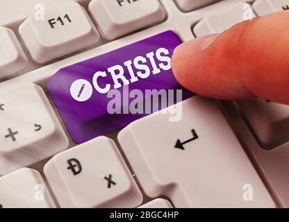 Writing note showing Crisis. Business concept for time when difficult or important decision must be made danger Stock Photo