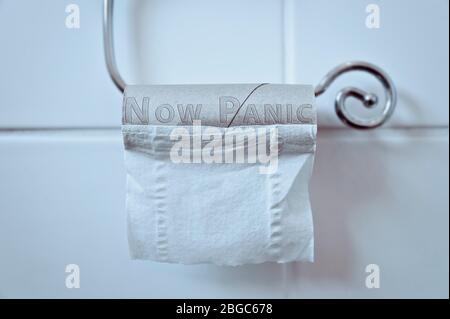 Empty Toilet Loo Roll reads 'NOW PANIC' Panic Buying Toilet Paper concept Coronavirus Covid-19 Pandemic Stock Photo