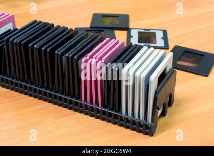 Old plastic slide film mount frames in a box on a wooden table. Close up image Stock Photo