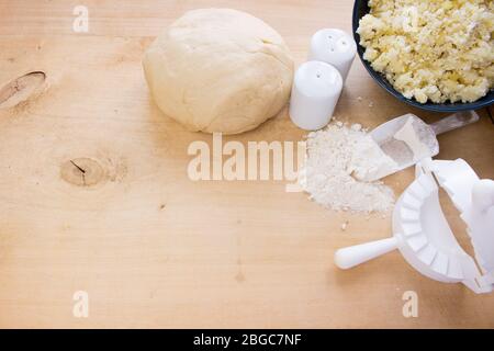 National Russian cuisine. Pierogi or pyrohy, vareniki, served with cottage cheese and potatoes on board.  Raw dumplings made of dough in handmade flou Stock Photo
